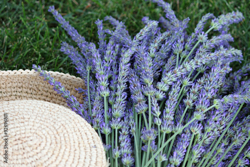 Fototapeta Naklejka Na Ścianę i Meble -  A Bouquet of Fresh Cut Lavender Beside a Straw Hat
