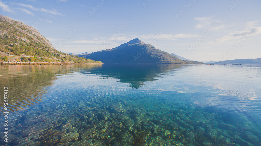 Beautiful vibrant summer norwegian landscape with coast of fjord with a blue sky, blue clear water, norway, norge