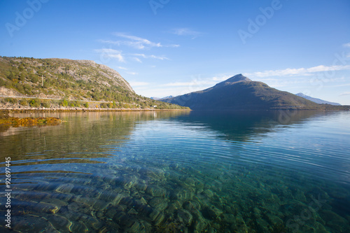 Beautiful vibrant summer norwegian landscape with coast of fjord with a blue sky, blue clear water, norway, norge photo