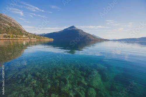 Beautiful vibrant summer norwegian landscape with coast of fjord with a blue sky, blue clear water, norway, norge