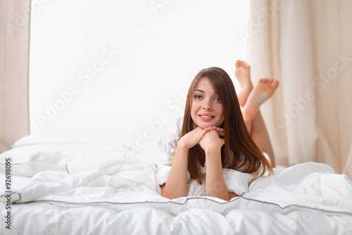 Portrait of beautiful woman on bed at bedroom
