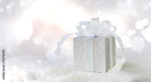 Silver gift on shiny and sparkling background