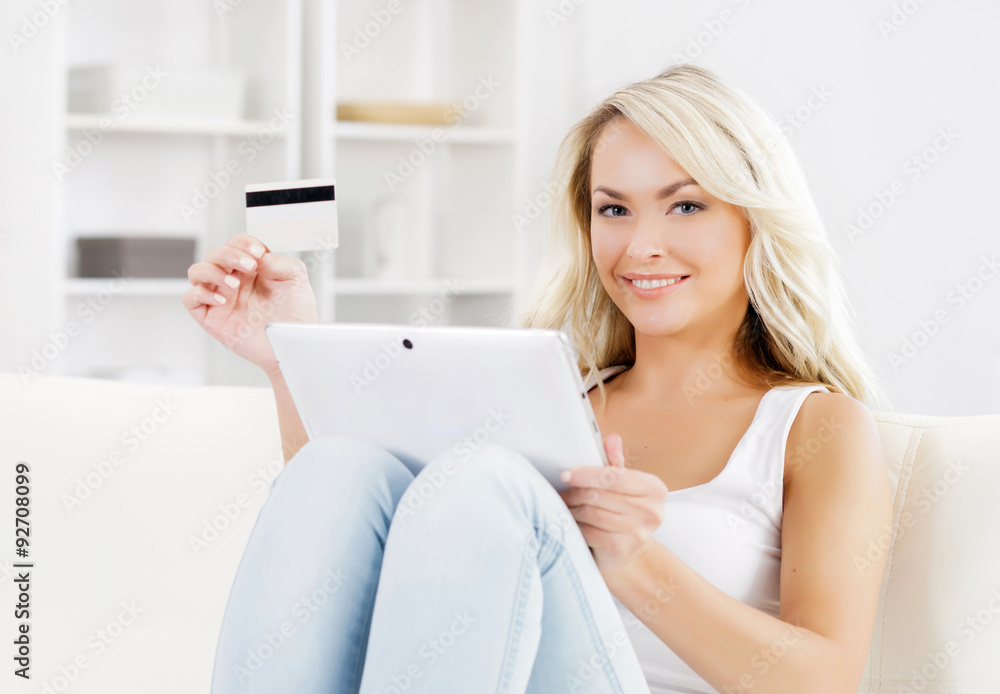 Attractive blond woman with a credit card and a tablet computer. Attractive blond woman with a credit card and a tablet computer.