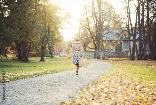 Beautiful woman enjoying a walk in the park in autumn © Acronym