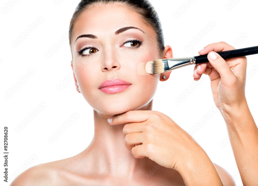 Makeup artist applying liquid tonal foundation on the face Makeup artist applying liquid tonal foundation on the face