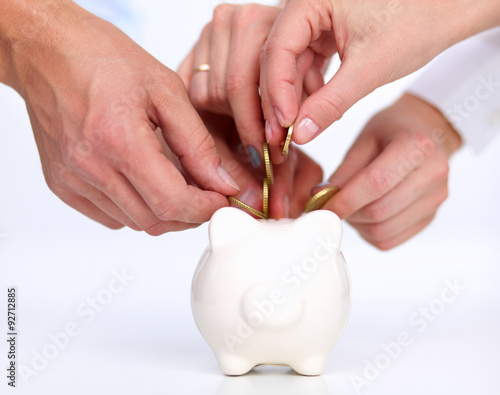 People putting coin into the piggy bank