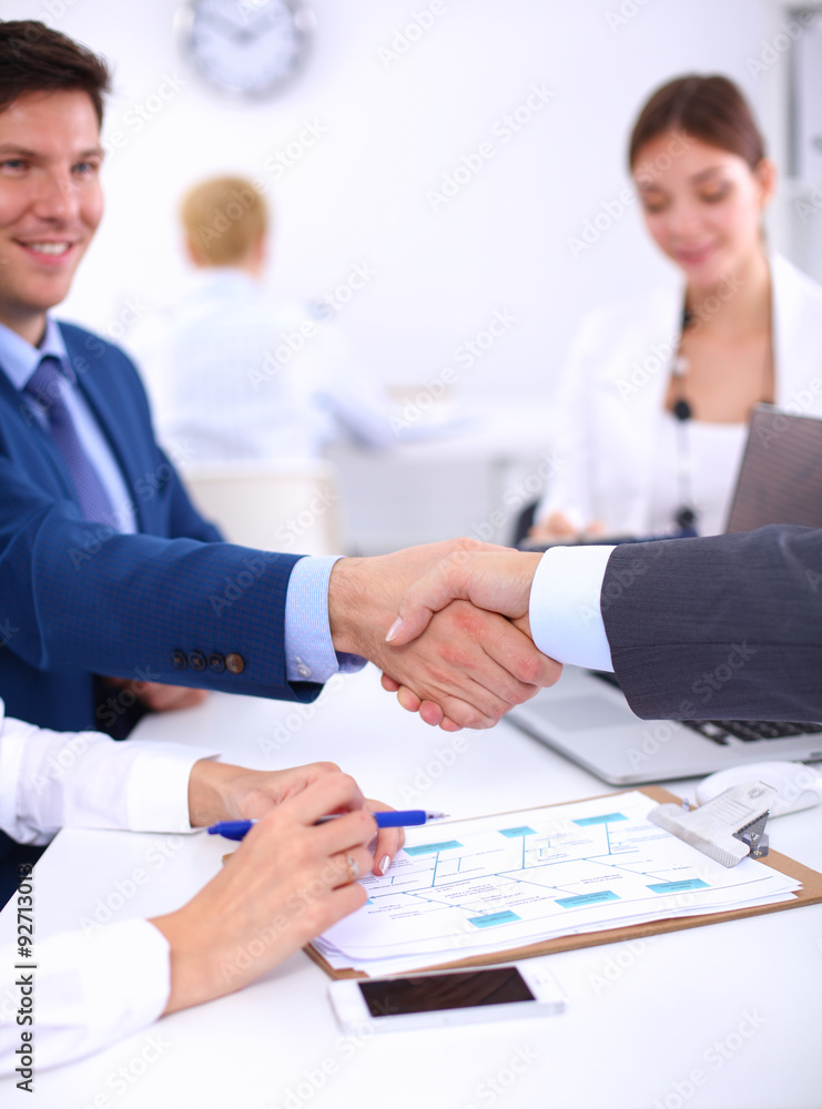 Business people shaking hands, finishing up a meeting, in office Business people shaking hands, finishing up a meeting, in office