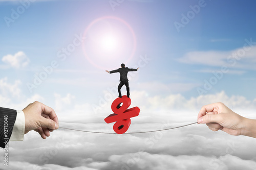 Two hands pulling rope businessman balancing percentage sign