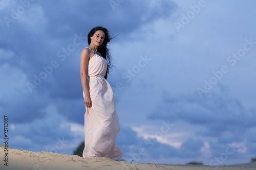 Beautiful woman walking on a sand dune