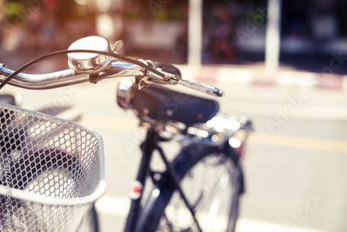 Fotografi Detail of a vintage bicycle handlebar resting in the city Street - Blurred backg