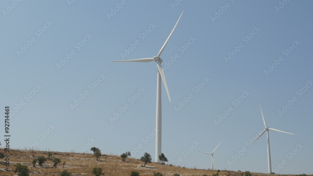 Wind turbines in a field with blue sky. 4K UHD.
