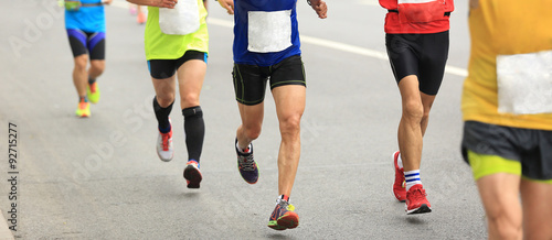 marathon runners running on city road.