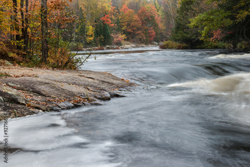 Small rapids and colorful autumn forest at Oxtongue river