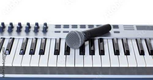 The microphone lies on the synthesizer keyboard