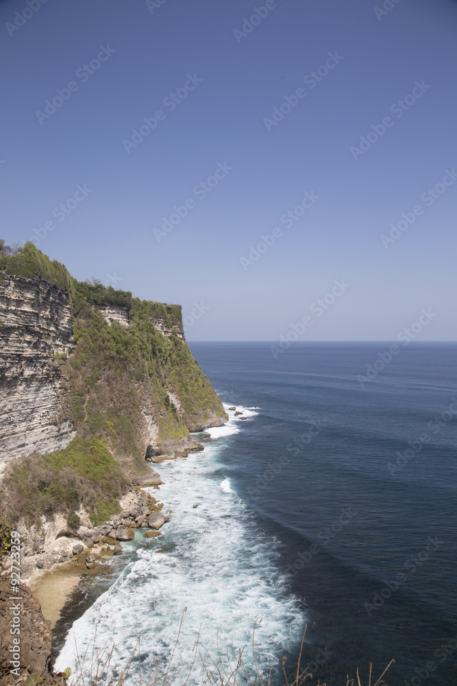 Calm sea with clear water and green coast in Bali
