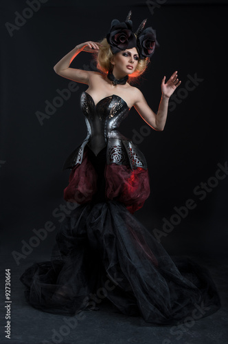 Portrait of beautiful blond woman in dark sexy corset in studio