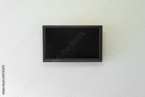 Black LCD or LED tv screen hanging on a wall background