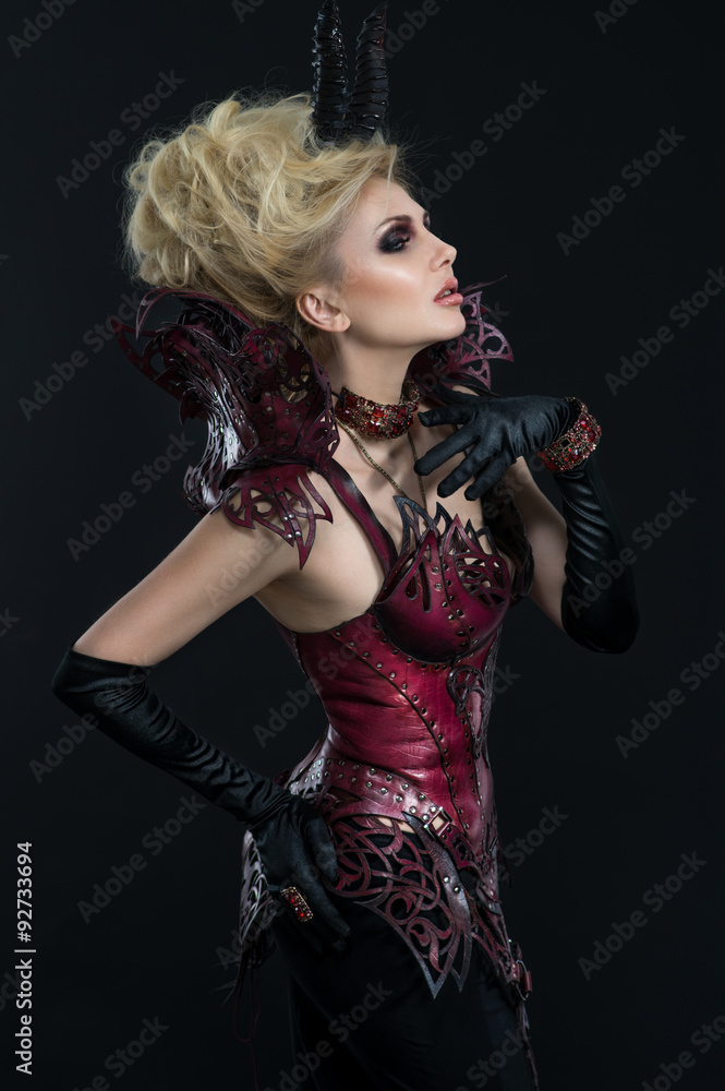 Portrait of beautiful devil woman in dark sexy dress in studio Portrait of beautiful devil woman in dark sexy dress in studio