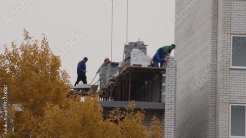 Wallpaper Mural a team of masons building brick multistory house in autumn Torontodigital.ca