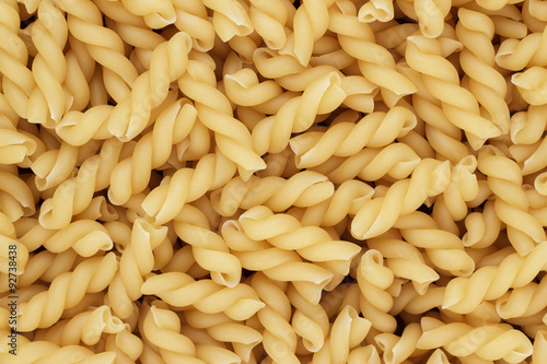 dry uncooked thick gemelli pasta texture background photo