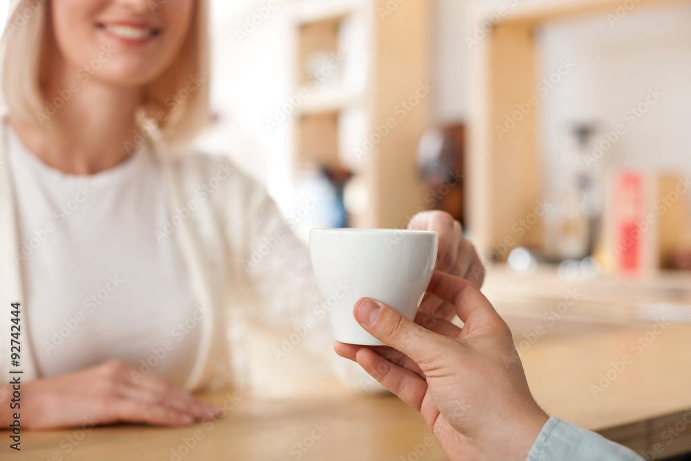 Professional male barista is serving his client Professional male barista is serving his client