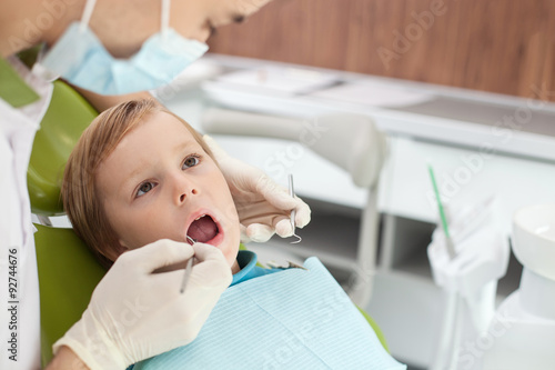 Professional young dental doctor is treating patient