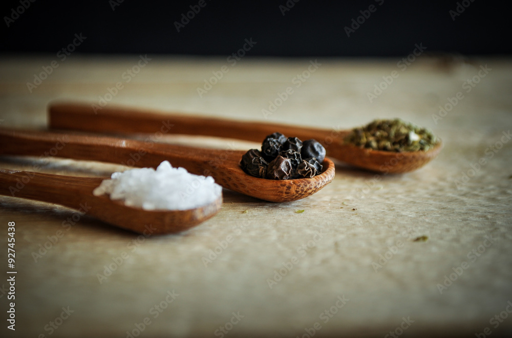 Sea salt and peppercorns and oregano on wooden spoons Sea salt and peppercorns and oregano on wooden spoons