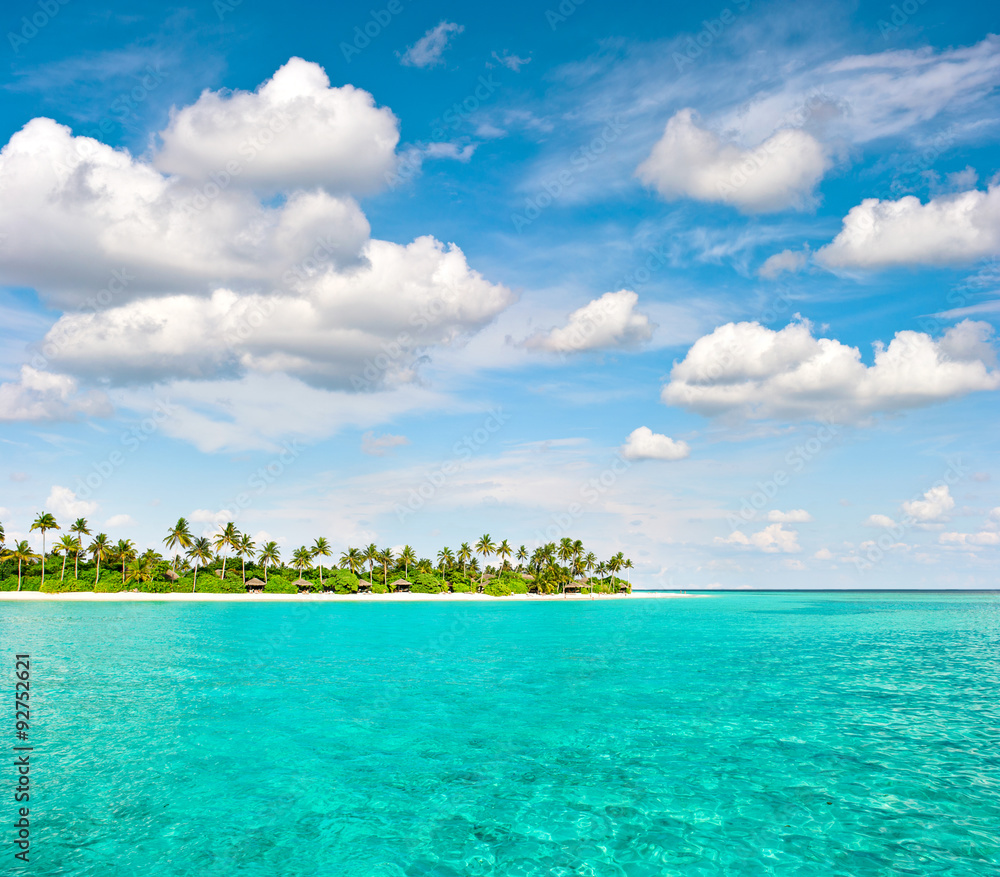 Tropical island beach with palm trees and cloudy blue sky Tropical island beach with palm trees and cloudy blue sky