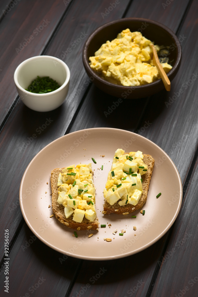 Egg Salad Sandwich, egg salad on wholegrain bread with chives, photographed with natural light (Selective Focus, Focus on the front of the sandwiches)