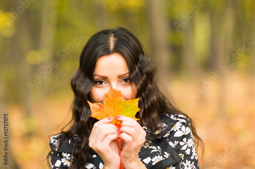 Portrait of an autumn woman holding leaves 
