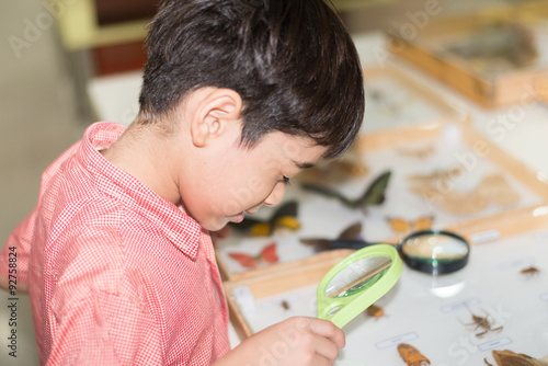 Little boy learning science class with microscope