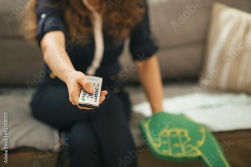 Closeup on football fan woman sitting on couch and watching tv