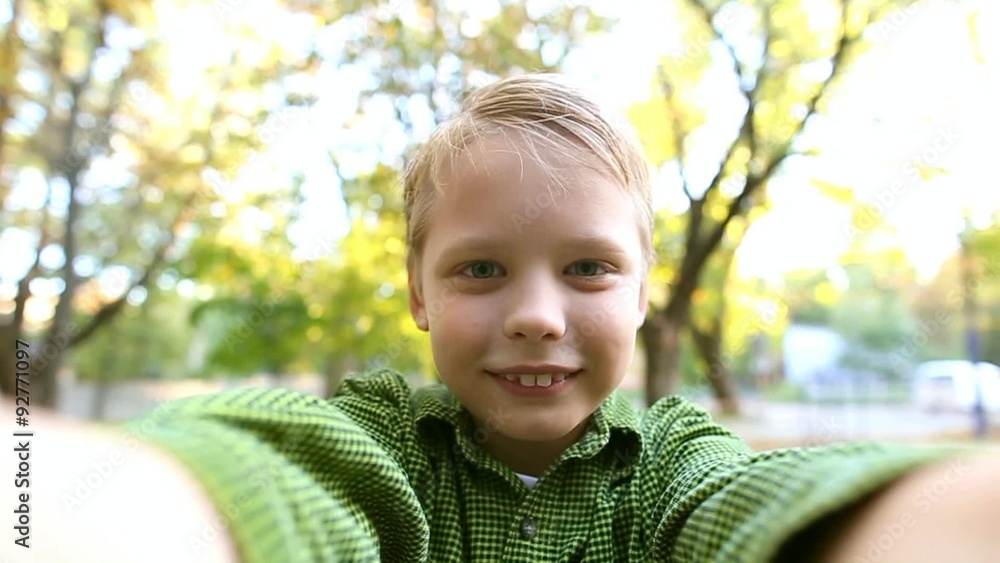 Funny kid making selfie while playing on swing. Funny face of boy. Slow motion video clip of cheerful 8 years old boy playing on urban playground and posing for self portrait. Child playing on swing Funny kid making selfie while playing on swing. Funny face of boy. Slow motion video clip of cheerful 8 years old boy playing on urban playground and posing for self portrait. Child playing on swing