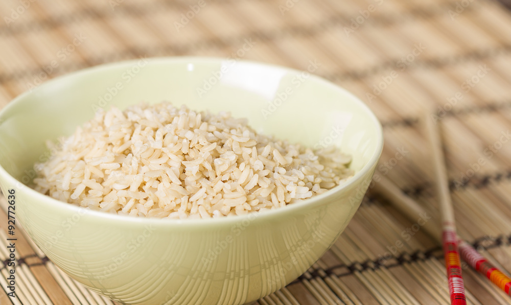 Boiled brown rice on bamboo washer with chopsticks