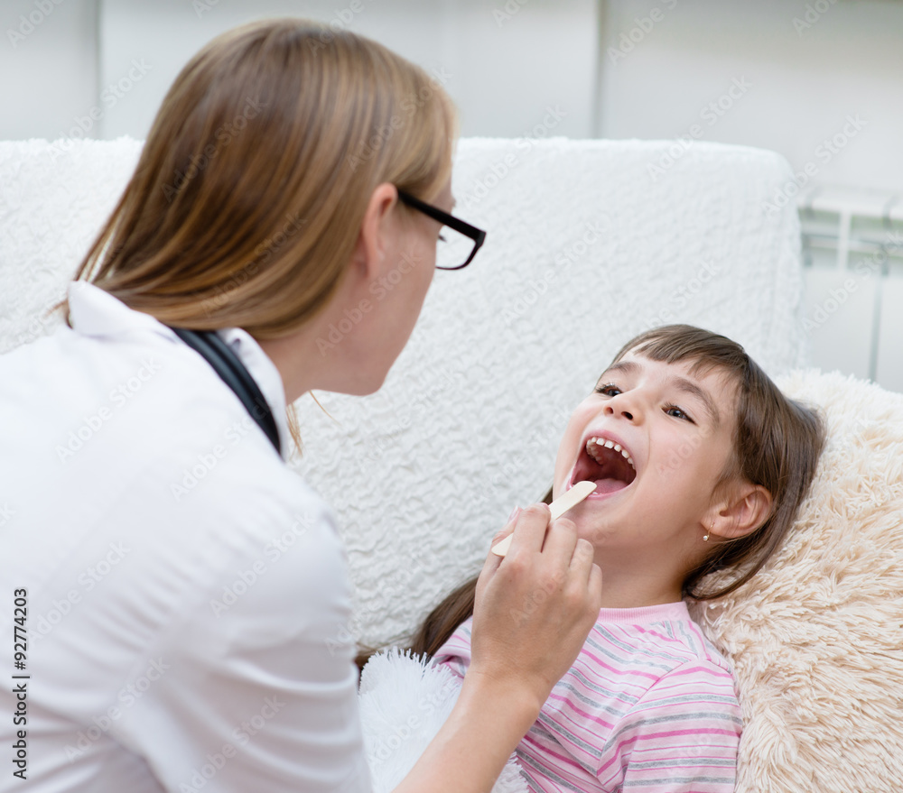 little girl having his throat examined by health professional little girl having his throat examined by health professional