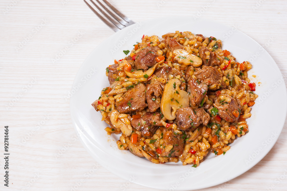 Rice with meat, vegetables and mushrooms on plate