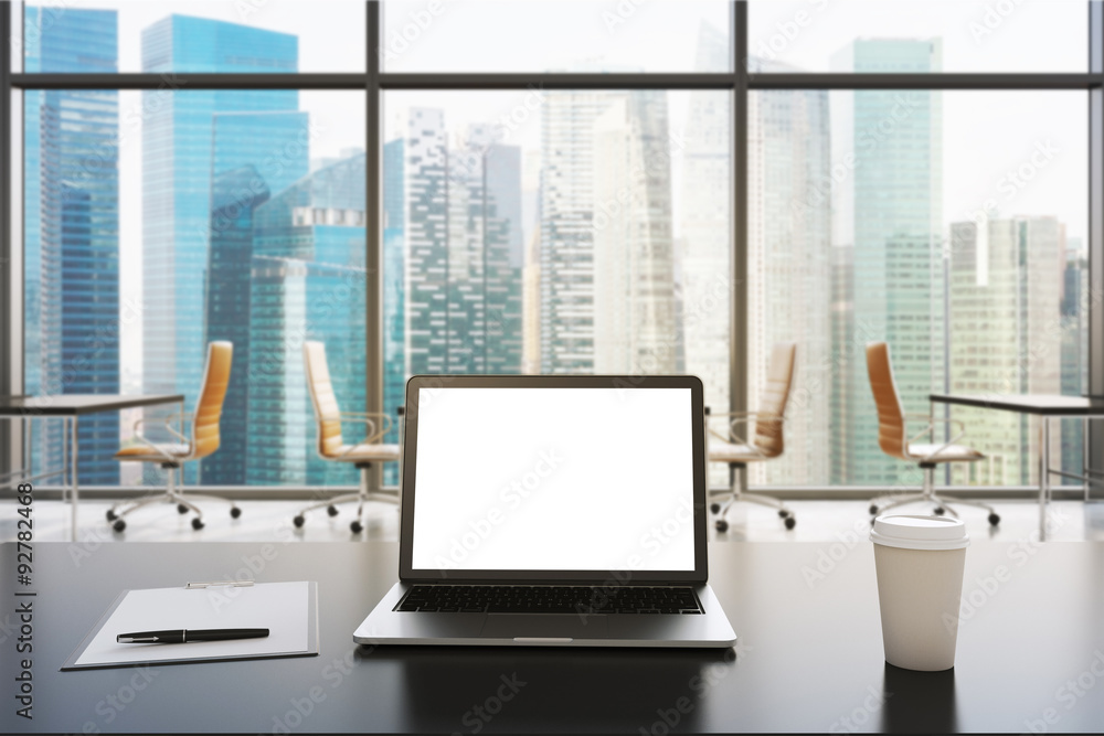 A workplace in a modern panoramic office in Singapore. A laptop with white screen, notepad and a coffee cup are on the black table. Open space. 3D rendering. Toned image. A workplace in a modern panoramic office in Singapore. A laptop with white screen, notepad and a coffee cup are on the black table. Open space. 3D rendering. Toned image.