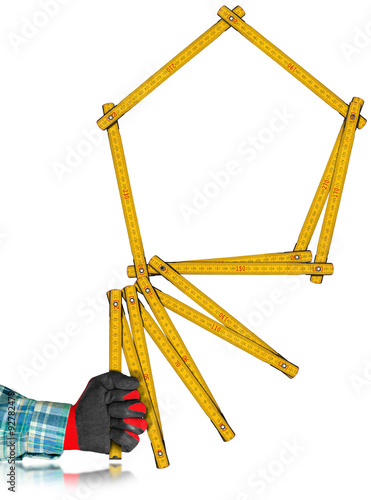 Gloved Hand Holding a Symbolic House / Hand with red and black work glove holding a yellow wooden meter ruler in the shape of house isolated on white background. Concept of house project 