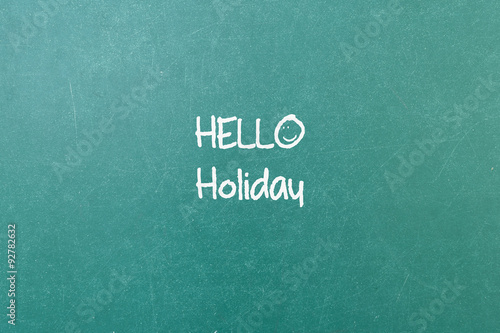 Green blackboard wall texture with a word Hello Holiday