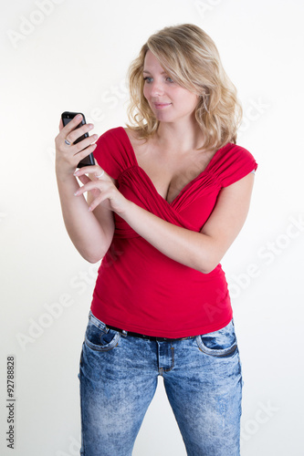 pretty girl with a red top looking at her mobile phone