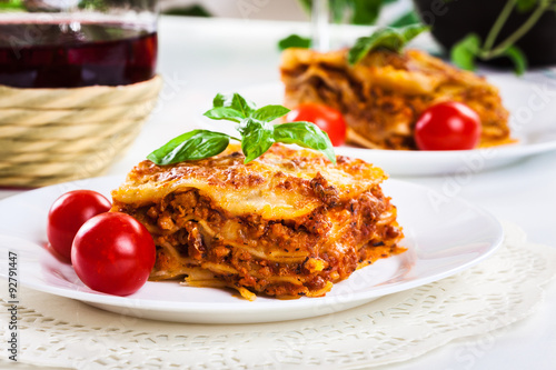 Piece of tasty hot lasagna with red wine..