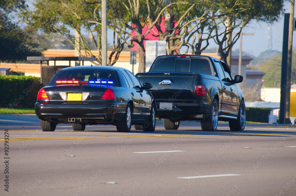 An unmarked police car has pulled over a truck for a traffic violation