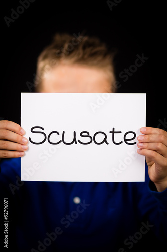 Child holding sign with Italian word Scusate - Sorry