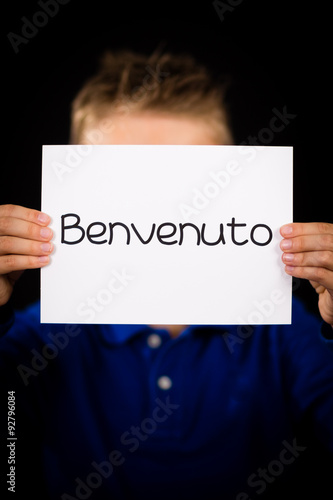 Child holding sign with Italian word Benvenuto - Welcome