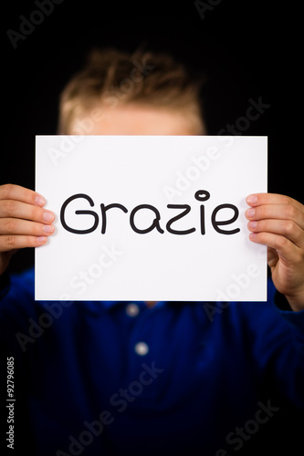 Child holding sign with Italian word Grazie - Thank You