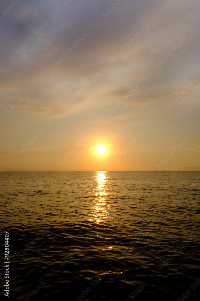 Naklejka premium Beautiful sunset sky with clouds above sea water