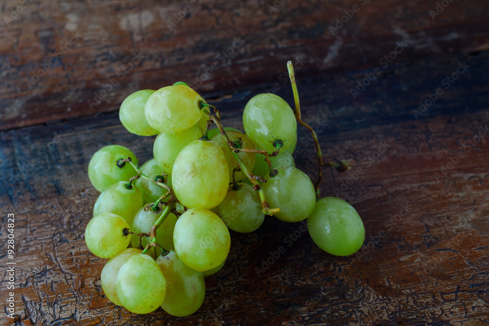 Uva gialla in primo piano su tavolo antico, frutta fresca di stagione, fragole e noci Uva gialla in primo piano su tavolo antico, frutta fresca di stagione, fragole e noci