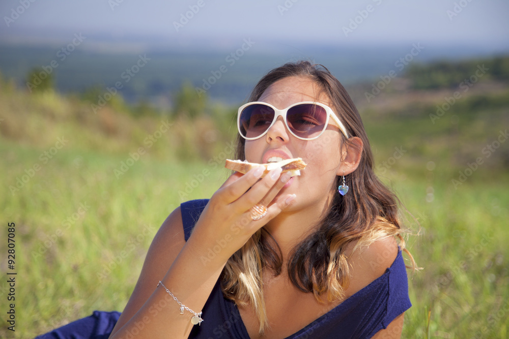 Young woman eating in nature. Young woman eating in nature.