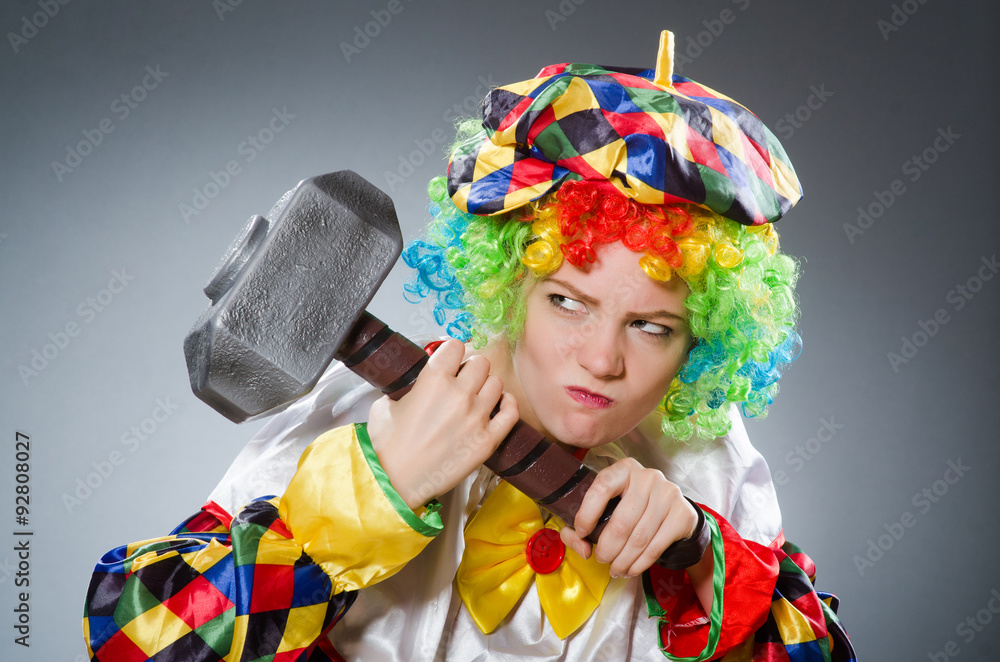 Clown with hammer in funny concept Clown with hammer in funny concept