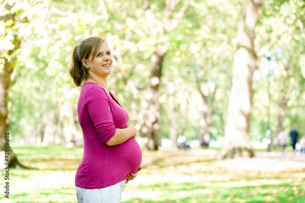 Happy and young pregnant woman in park in summer Happy and young pregnant woman in park in summer